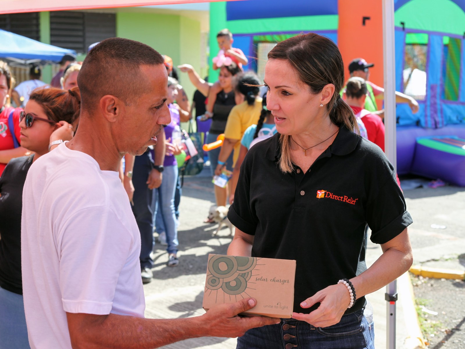 A Unite to Light solar charger being handed to a Puerto Rico resident at a Direct Relief distribution event