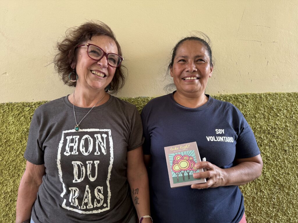 Two women holding a solar light.