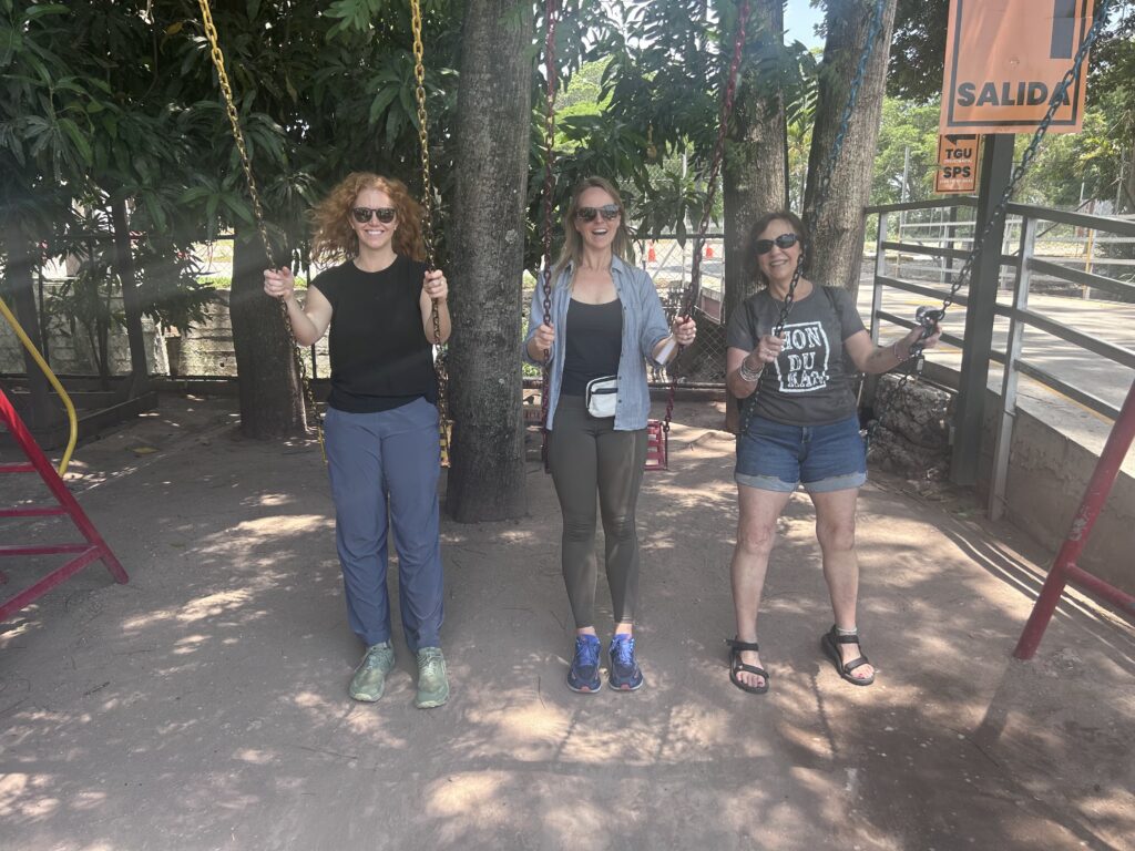 Three women on a swing set in Honduras
