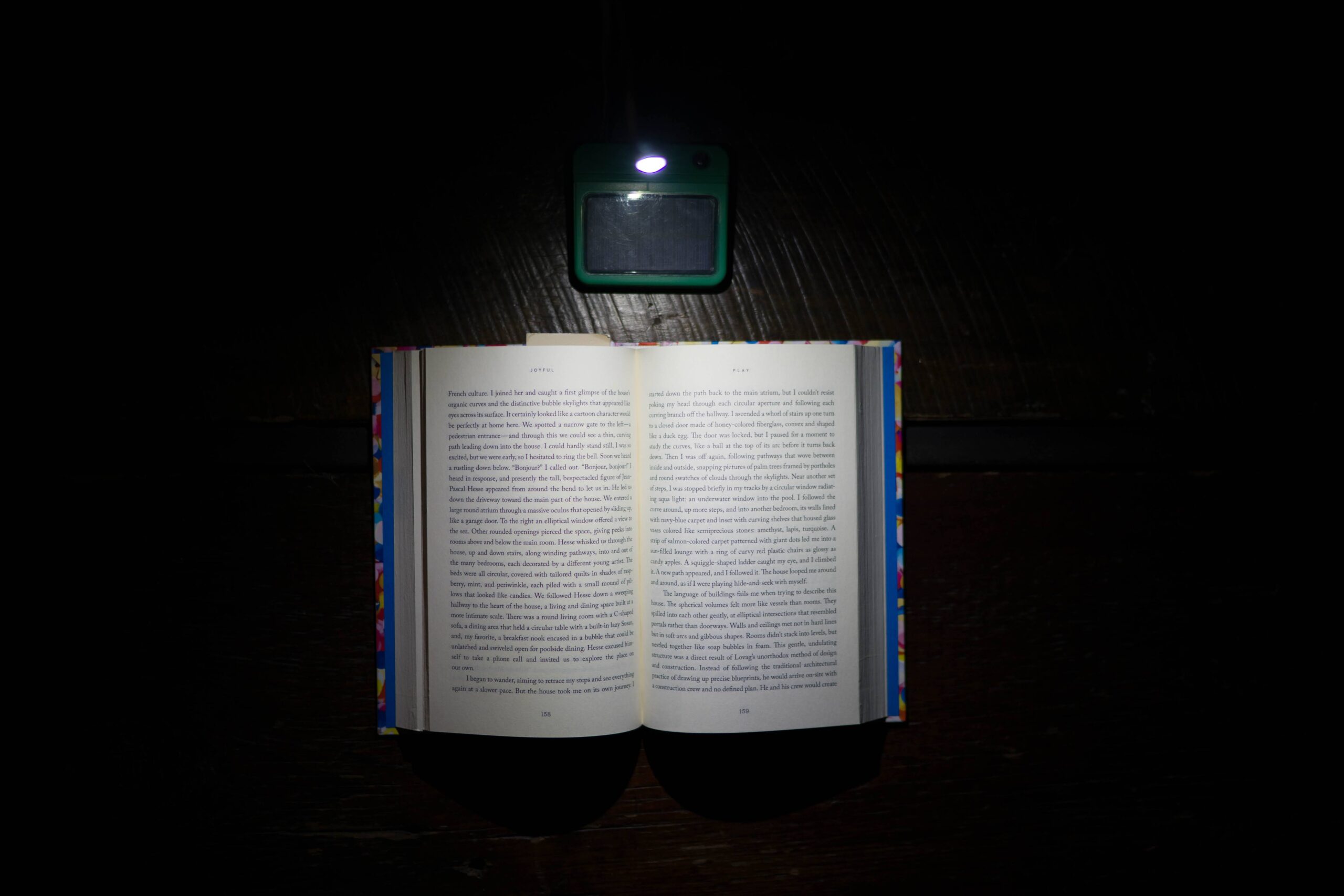 A Luke Light clipped above an open book, lighting the pages in a dark room